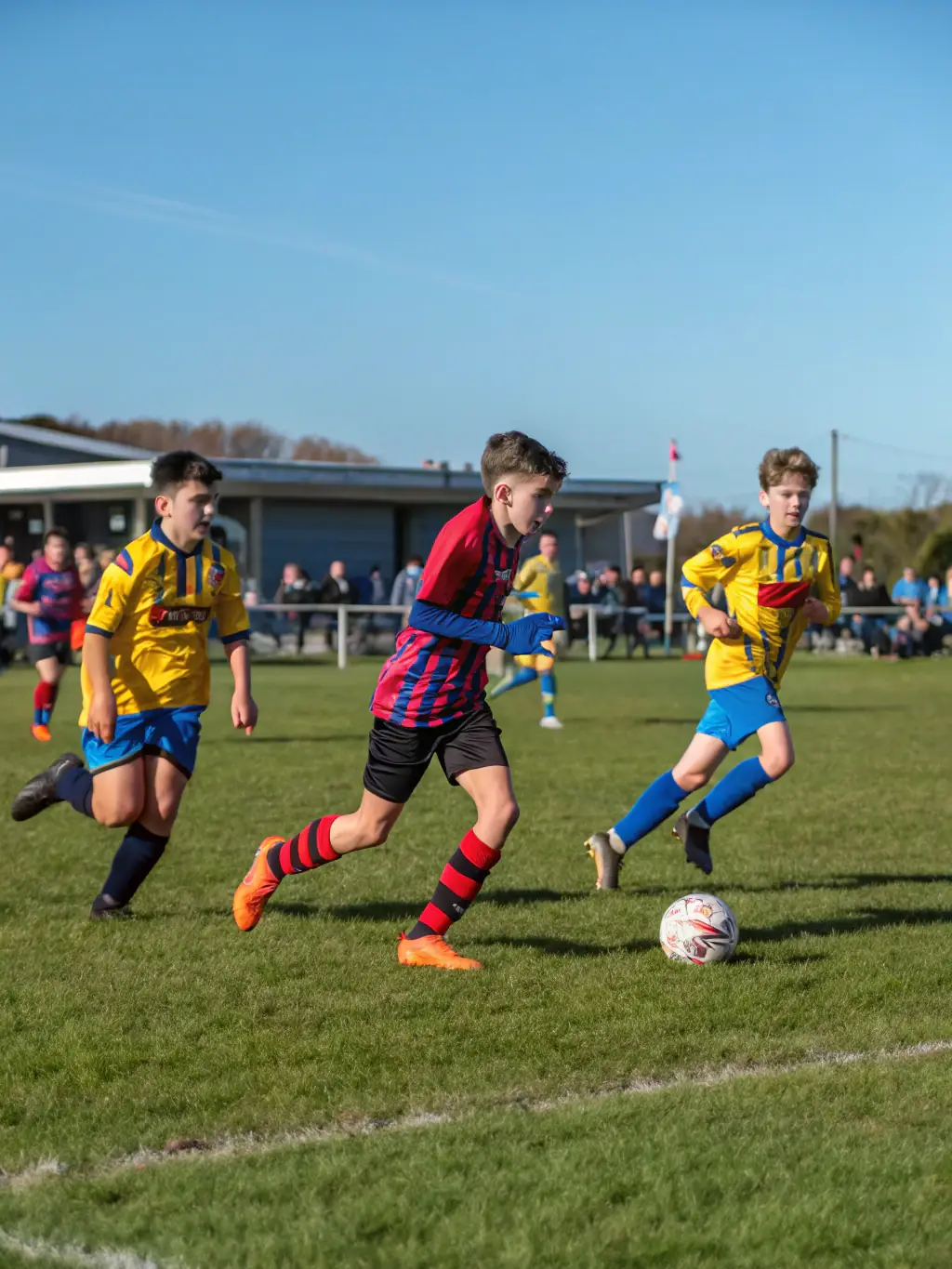 Teenagers in FCBO FCB LES OLIVES gear engaged in a competitive yet friendly football match, showcasing teamwork and sportsmanship.